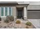 Inviting front entrance with a decorative door, manicured landscaping, and a two-car garage at 21186 W Hillcrest Blvd, Buckeye, AZ 85396