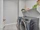 Modern laundry room with gray front load washer and dryer and decor on the shelf above at 21186 W Hillcrest Blvd, Buckeye, AZ 85396