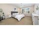 This main bedroom features neutral walls, carpet floors, large windows, and a decorative bedframe at 22858 E Marsh Rd, Queen Creek, AZ 85142