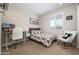 Bedroom features a desk, comfy rocking chair, plush carpet, and a bed with patterned bedding at 22858 E Marsh Rd, Queen Creek, AZ 85142