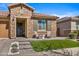 Cozy front porch with stone detail, charming chairs, and a beautifully landscaped yard at 22858 E Marsh Rd, Queen Creek, AZ 85142