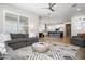 Open-concept living room featuring a comfortable sofa, stylish rug, and seamless flow into the kitchen at 22858 E Marsh Rd, Queen Creek, AZ 85142