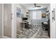 Modern office with a leaf-patterned rug, a contemporary desk, and accent wall with floating shelves at 22858 E Marsh Rd, Queen Creek, AZ 85142