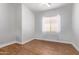 This bedroom features wood-look tile flooring and a window with sheer curtains at 2436 W Kachina Trl, Phoenix, AZ 85041