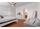 Bright bedroom with wood floors, a ceiling fan, and a sitting area with a grey couch at 2436 W Kachina Trl, Phoenix, AZ 85041