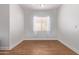 This bedroom features wood-look tile flooring and a window with sheer curtains at 2436 W Kachina Trl, Phoenix, AZ 85041