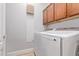 Laundry room featuring a white washer and dryer with overhead cabinets at 2436 W Kachina Trl, Phoenix, AZ 85041