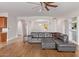 Inviting living room with a large gray sectional, archways, and wood floors throughout at 2436 W Kachina Trl, Phoenix, AZ 85041