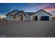 Exterior view of a home with a desert landscape, three-car garage and an inviting entryway at 2438 N 113Th St, Mesa, AZ 85207