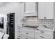 Close-up of a modern kitchen featuring white cabinets, marble countertops, and sleek appliances at 2438 N 113Th St, Mesa, AZ 85207