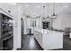 Bright kitchen showcasing white cabinets, stainless steel appliances, and an island with a marble countertop under modern pendant lighting at 2438 N 113Th St, Mesa, AZ 85207