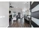 Open-concept living room featuring dark hardwood floors, a ceiling fan, and modern lighting at 2438 N 113Th St, Mesa, AZ 85207