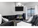 Cozy living room with black leather reclining chairs, fireplace, and a TV, providing a comfortable and modern space at 2438 N 113Th St, Mesa, AZ 85207