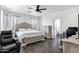 A spacious main bedroom includes a tufted headboard, a ceiling fan, and a door to the main bathroom at 2438 N 113Th St, Mesa, AZ 85207