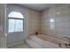 Tiled bathroom with a bathtub and arched window at 2542 S Playa --, Mesa, AZ 85202