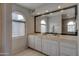 Well-lit bathroom features double vanity, large mirror, and arched window at 2542 S Playa --, Mesa, AZ 85202