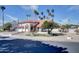 Inviting two-story home featuring a red tile roof, white stucco walls, and lush desert landscaping with mature palm trees at 2542 S Playa --, Mesa, AZ 85202