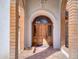 Close up view of a wooden arched doorway framed by brick pillars, creating a grand and inviting entrance at 2542 S Playa --, Mesa, AZ 85202