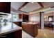 Well-lit kitchen with dark wood cabinets, a central island, and a view of the dining area at 2542 S Playa --, Mesa, AZ 85202