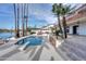 Backyard pool with a diving board framed by lush landscaping, leading to a patio and tranquil lake views at 2542 S Playa --, Mesa, AZ 85202