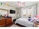 Bright bedroom with a ceiling fan, dresser, and large window at 25732 W St James Ave, Buckeye, AZ 85326