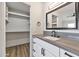 Modern bathroom features a walk-in closet, gray countertops, and white shaker cabinets at 3026 W Ross Ave, Phoenix, AZ 85027