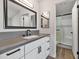 Well-lit bathroom features a walk-in shower with glass door, grey countertops and black fixtures at 3026 W Ross Ave, Phoenix, AZ 85027