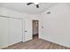 A clean, bright bedroom with a fan, closet, neutral walls, and wood-look floors at 3026 W Ross Ave, Phoenix, AZ 85027