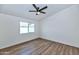 Bright bedroom features wood-look floors, a modern ceiling fan, and a window for natural light at 3026 W Ross Ave, Phoenix, AZ 85027