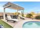 Outdoor pool area with a barbecue, dining space and lounge chairs beneath a shaded pergola at 303 S 197Th Ave, Buckeye, AZ 85326