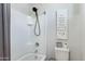 Modern white bathroom featuring a shower, tub, and toilet with decorative wall art at 303 S 197Th Ave, Buckeye, AZ 85326