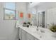 Bathroom featuring a large mirror above a white vanity with framed decor and a window offering natural light at 303 S 197Th Ave, Buckeye, AZ 85326