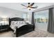 Spacious bedroom with dark wood furniture, neutral walls, plush rug, and ample natural light from large windows at 303 S 197Th Ave, Buckeye, AZ 85326