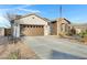 Home with a neutral stucco, stone facade, desert landscaping, and a spacious driveway at 303 S 197Th Ave, Buckeye, AZ 85326