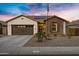 Charming single-story home with a well-manicured lawn, stone accents, and a welcoming front entrance at 303 S 197Th Ave, Buckeye, AZ 85326