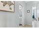 Hallway view of bathroom with white vanity and decorative art leading to bright bedroom in modern home at 303 S 197Th Ave, Buckeye, AZ 85326