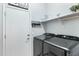 Modern laundry room with a side-by-side washer and dryer, plus storage shelves, and direct access to outside at 303 S 197Th Ave, Buckeye, AZ 85326