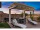 Outdoor patio with a pergola, BBQ grill, lounge chairs, a dining table and desert landscaping at 303 S 197Th Ave, Buckeye, AZ 85326