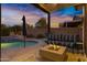 Cozy outdoor patio with a fire pit, comfortable seating, and a view of the pool and spa at 303 S 197Th Ave, Buckeye, AZ 85326