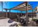 Charming outdoor patio with a dining table, hammock, and pergola, perfect for relaxing and entertaining guests at 3120 N 67Th Ln # 31, Phoenix, AZ 85033