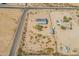 Wide aerial view of desert lot featuring metal roof home, additional buildings, and desert plants at 31555 N Royce Rd, San Tan Valley, AZ 85144