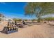 Backyard showcasing seating and a fire pit, enhanced by mature trees and scenic desert views at 31555 N Royce Rd, San Tan Valley, AZ 85144