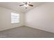 A neutral-colored bedroom with a ceiling fan and large window at 31555 N Royce Rd, San Tan Valley, AZ 85144