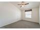 A neutral bedroom with a ceiling fan and a large window at 31555 N Royce Rd, San Tan Valley, AZ 85144