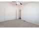 A neutral bedroom with a ceiling fan and a door leading into another room at 31555 N Royce Rd, San Tan Valley, AZ 85144