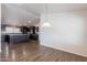 Modern kitchen with dark cabinets, wood floors, and a large island with a granite countertop at 31555 N Royce Rd, San Tan Valley, AZ 85144