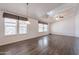 Bright living room with wood floors, vaulted ceilings, and multiple windows with neutral blinds at 31555 N Royce Rd, San Tan Valley, AZ 85144