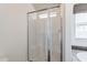 Glass shower stall with bench in bathroom, next to soaking tub, and window with shade at 31555 N Royce Rd, San Tan Valley, AZ 85144