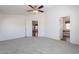 A bedroom with light gray carpet, white walls, a ceiling fan, and two doors at 31555 N Royce Rd, San Tan Valley, AZ 85144