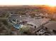 Sunset aerial view of the property showcasing the pool, putting green, desert landscape, and mountain views at 31709 N 16Th Ave, Phoenix, AZ 85085